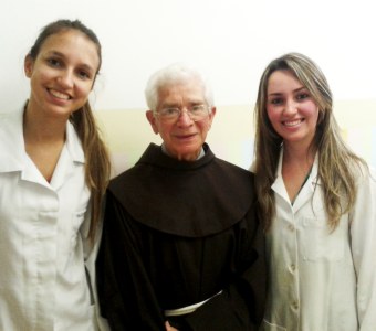 As alunas Paula Oliveira Capelo e Marcela Rosane Martins com o Frei Agostino Salvador Piccolo